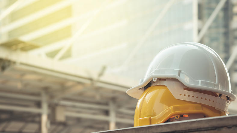 white, yellow hard safety helmet hat for safety project of workman as engineer or worker, on concrete floor on city white, yellow hard safety helmet hat for safety project of workman as engineer or worker, on concrete floor on city