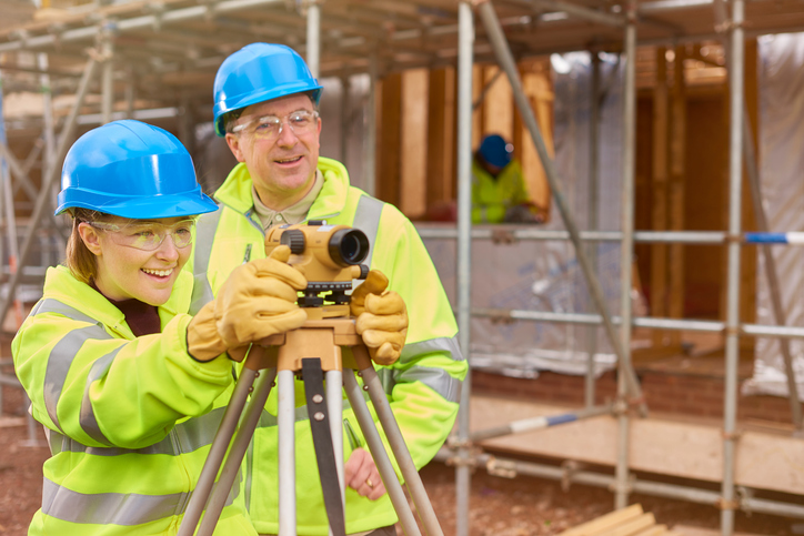 happy female construction trainee with tutor