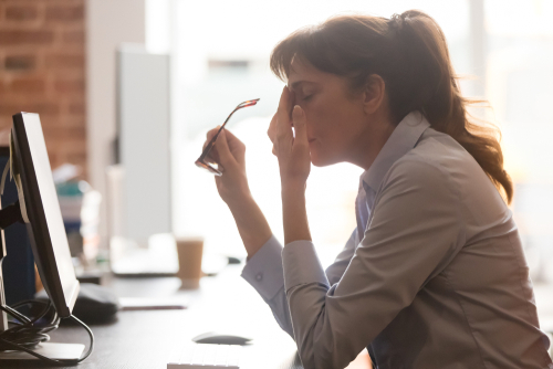 Exhausted,Female,Worker,Sit,At,Office,Desk,Take,Off,Glasses